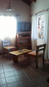 uma sala de estar com uma mesa e cadeiras e um piano em Wilka Pacha - Casas Serranas em Capilla del Monte