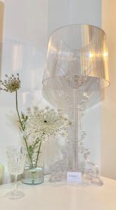 una lámpara de cristal sobre una mesa con flores en Q-riosity boutique rooms en Quartu SantʼElena