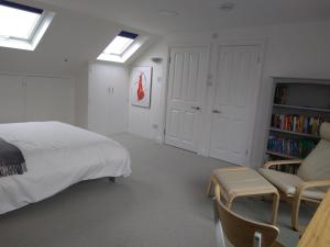 sypialnia z łóżkiem, kanapą i półką na książki w obiekcie Sandra & Andrew's B&B w Londynie