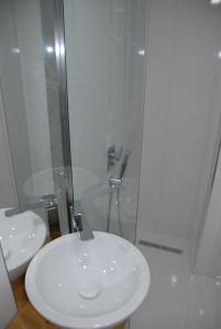y baño con lavabo blanco y ducha. en Villa Mucho, en Sarandë