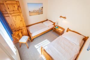 a small bedroom with two beds and a cabinet at Ferienbungalow Fischerstrand in Binz