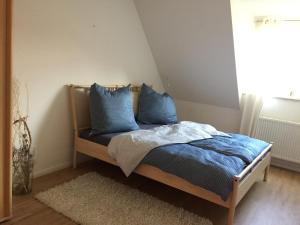ein Bett mit blauen Kissen in einem Schlafzimmer in der Unterkunft Meeresbrise in Graal-Müritz