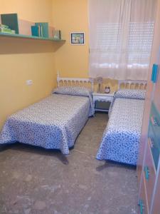 a room with two beds and a window at Casa Rosa in Alcañiz