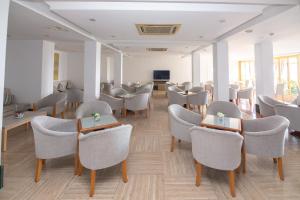 a waiting room with chairs and tables and a tv at Hotel Club S'Illot in S'Illot