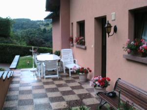 un patio con mesa y sillas en un suelo a cuadros en GITE CHEZ SYLVIE, en Fréland