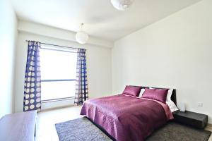 a bedroom with a purple bed and a window at Full Seaview⎮High Floor⎮3 minutes to the beach in Dubai