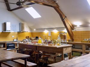 een grote keuken met houten tafels en gele tegels bij The Passenger Hostel in Porto