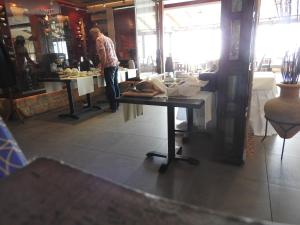 a man standing at a table in a store at Hill View Hotel Apartments in Pissouri