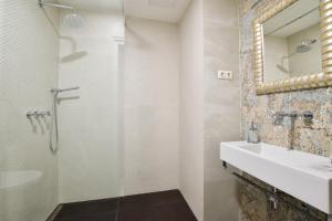 een badkamer met een douche, een wastafel en een spiegel bij Luxury Apartment by Hi5 - Október 6 Street in Boedapest