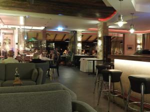 a restaurant with chairs and tables and a bar at Hill View Hotel Apartments in Pissouri