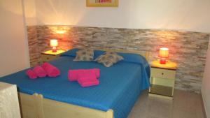 カーラゴノネにあるCasa Verdeのベッドルーム(ピンクの枕が付いた青いベッド付)
