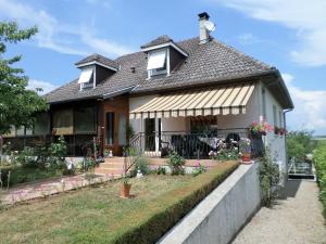 a house with a porch and flowers in the yard at Maison avec véranda proche du centre ville in Rignac - Aveyron
