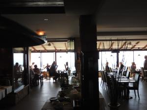a room with people sitting at tables in a restaurant at Hill View Hotel Apartments in Pissouri