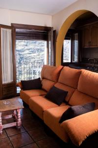 a living room with a couch and a large window at Apartamentos Vista Veleta in Capileira