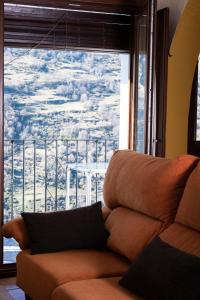 a couch in a room with a large window at Apartamentos Vista Veleta in Capileira