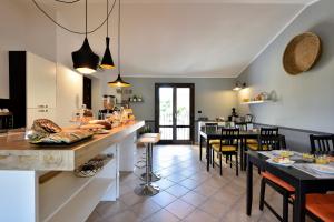 una cucina e una sala da pranzo con tavolo e sedie di La Tortorella Room & Apartment a Tortolì