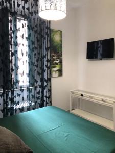 a bedroom with a bed and a tv and a window at giolitti central room in Rome