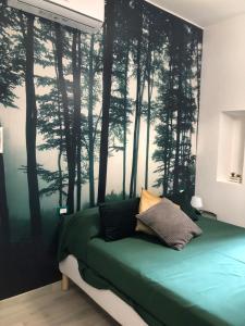 a bedroom with a bed with a forest wall mural at giolitti central room in Rome