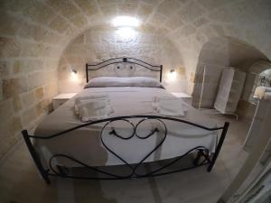 una camera con un letto in un tunnel di pietra di casa principe di napoli a Polignano a Mare