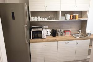 a kitchen with a refrigerator and a microwave at DIMORA FLEGREA room & breakfast in Pozzuoli