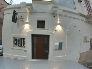 - un petit bâtiment blanc avec une porte rouge dans l'établissement casa principe di napoli, à Polignano a Mare