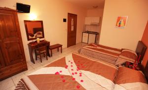 a bedroom with a bed and a desk and a mirror at Kostalina Hotel Studios in Limenas