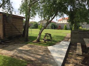 a yard with a tree and a playground at Les Palmiers in Pornic