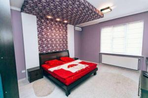 a bedroom with a red bed in a purple room at Apartments in Uzhgorod in Uzhhorod