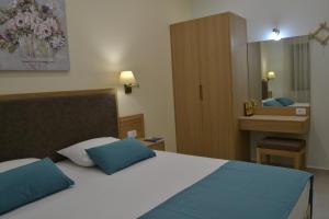 a bedroom with a bed with blue pillows and a mirror at Romantica Apartments in Falasarna