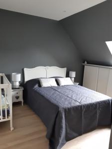 a bedroom with a large bed with a blue blanket at Cosy Maison Honfleur in Honfleur