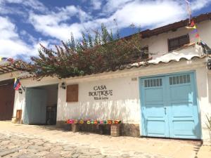 a building with a blue door and flowers on the roof at Hotel Casa Boutique Villa de Leyva in Villa de Leyva