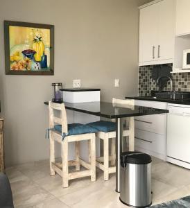 a kitchen with a table and two chairs and a sink at Indigo Place - Blue in Hermanus