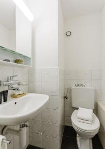 La salle de bains blanche est pourvue d'un lavabo et de toilettes. dans l'établissement Rent a Home Delsbergerallee - Self Check-In, à Bâle