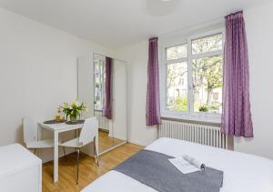 a bedroom with a bed and a desk and a window at Rent a Home Delsbergerallee - Self Check-In in Basel