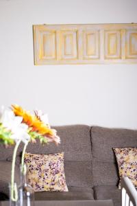 a living room with a couch and flowers on a table at Apartamentos Vista Veleta in Capileira