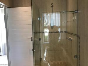 a shower with a glass door in a bathroom at Indigo Place - Blue in Hermanus