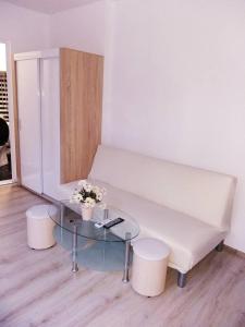 a living room with a white couch and a glass table at STUDIO SUNRISE in Varna City