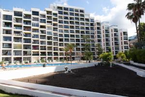a large apartment building with a large yard in front of it at Modern Apartment with pool and Wifi in Playa Fañabe