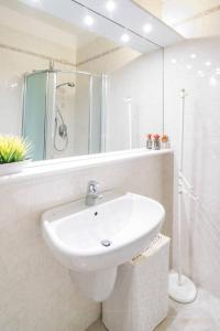 biała łazienka z umywalką i prysznicem w obiekcie Galilei61 - 3 camere, 2 bagni, garage e vista mare w San Remo
