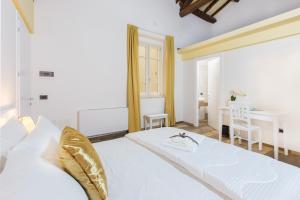 a bedroom with a white bed and a table at Residenza le Scalette in Cagliari
