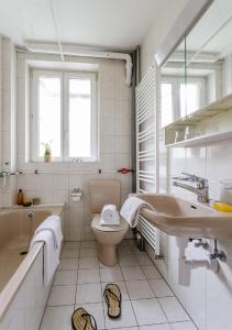 ein Badezimmer mit einer Badewanne, einem WC und einem Waschbecken in der Unterkunft Rent a Home Eptingerstrasse - Self Check-In in Basel