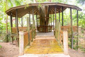 a wooden bridge with a gazebo with a tree on it at Log 33 in Ocho Rios