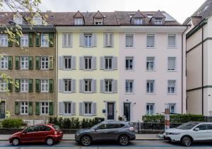un edificio blanco con coches estacionados frente a él en Rent a Home Eptingerstrasse - Self Check-In, en Basilea