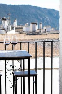 two glasses of wine sitting on a table on a balcony at Apartamentos Vista Veleta in Capileira