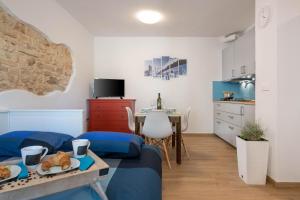 a room with a bed and a table and a kitchen at Studio Q in Fažana