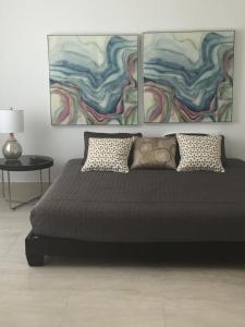 um quarto com uma cama com duas pinturas na parede em MAR DEL NORTE em San Juan