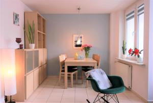 ワルシャワにあるStylish and spacious by Cooee Apartmentsのダイニングルーム(テーブル、緑の椅子付)