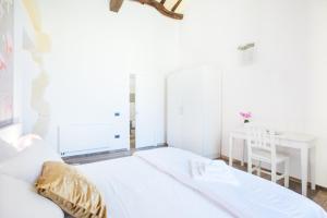 a bedroom with a white bed and white walls at Residenza le Scalette in Cagliari