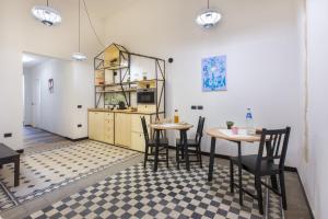 
a kitchen with a table, chairs, and a refrigerator at Residenza le Scalette in Cagliari
