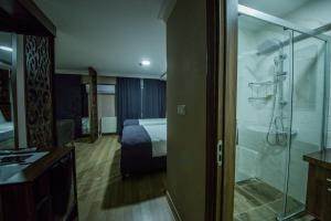 a hotel room with a bathroom with a bed and a shower at Fidanoglu Suite Hotel in Kesan